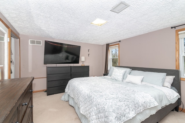 bedroom with light carpet, visible vents, and a textured ceiling