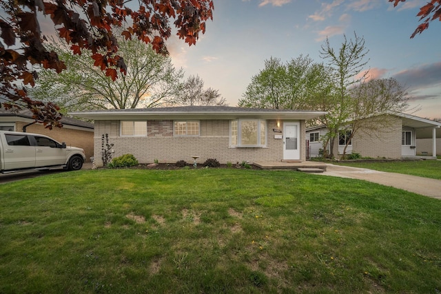 single story home with a front lawn and brick siding