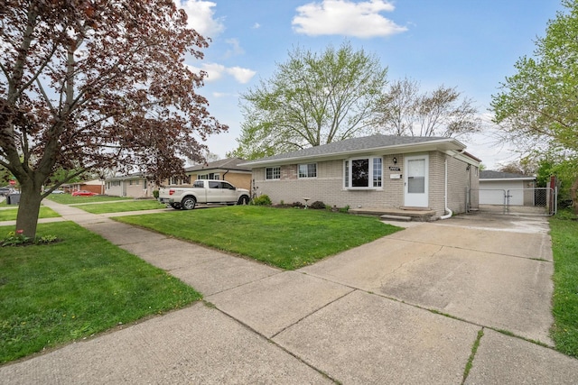 view of front facade with a front yard, brick siding, fence, and a gate