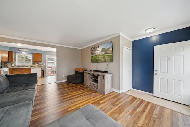 living area featuring baseboards, light wood finished floors, and crown molding
