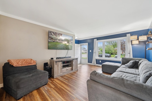 living room featuring baseboards, ornamental molding, and wood finished floors