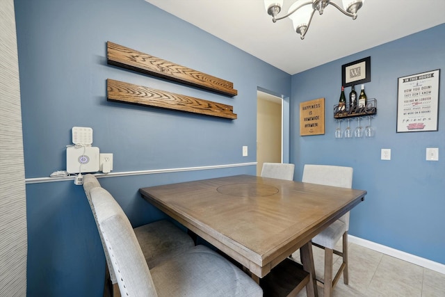 dining room with an inviting chandelier, baseboards, and light tile patterned floors