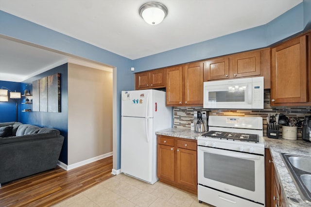 kitchen with brown cabinetry, white appliances, and decorative backsplash