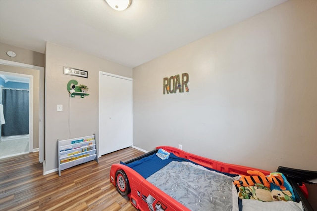 bedroom featuring baseboards and wood finished floors