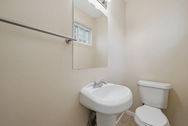half bath featuring toilet and a sink