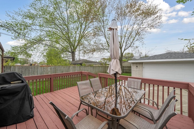 wooden terrace with a garage, area for grilling, outdoor dining area, an outdoor structure, and a fenced backyard