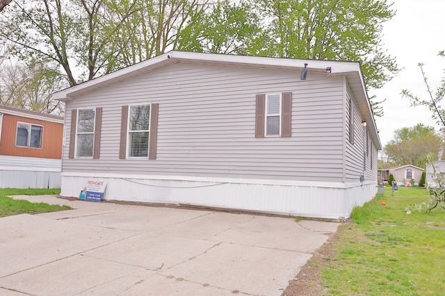 view of side of home with a patio and a yard
