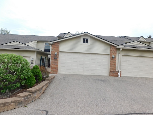 townhome / multi-family property with brick siding and driveway