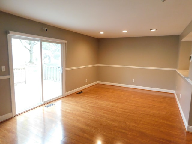 unfurnished room with visible vents, recessed lighting, baseboards, and wood finished floors