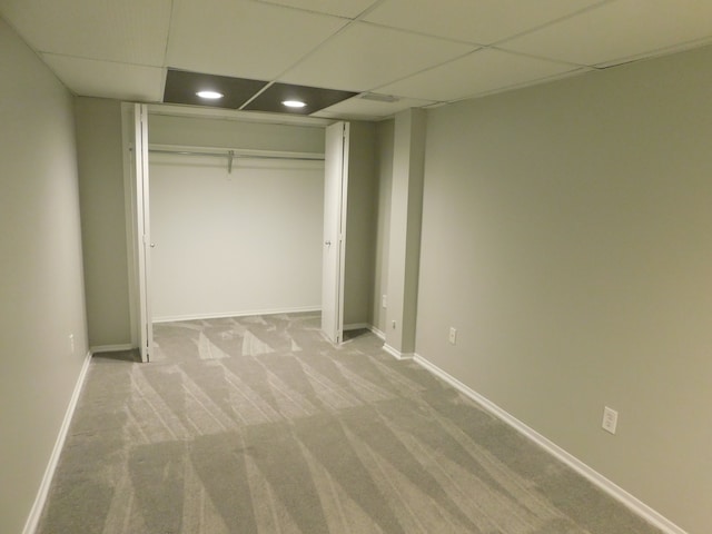 unfurnished bedroom with carpet floors, a paneled ceiling, recessed lighting, baseboards, and a closet