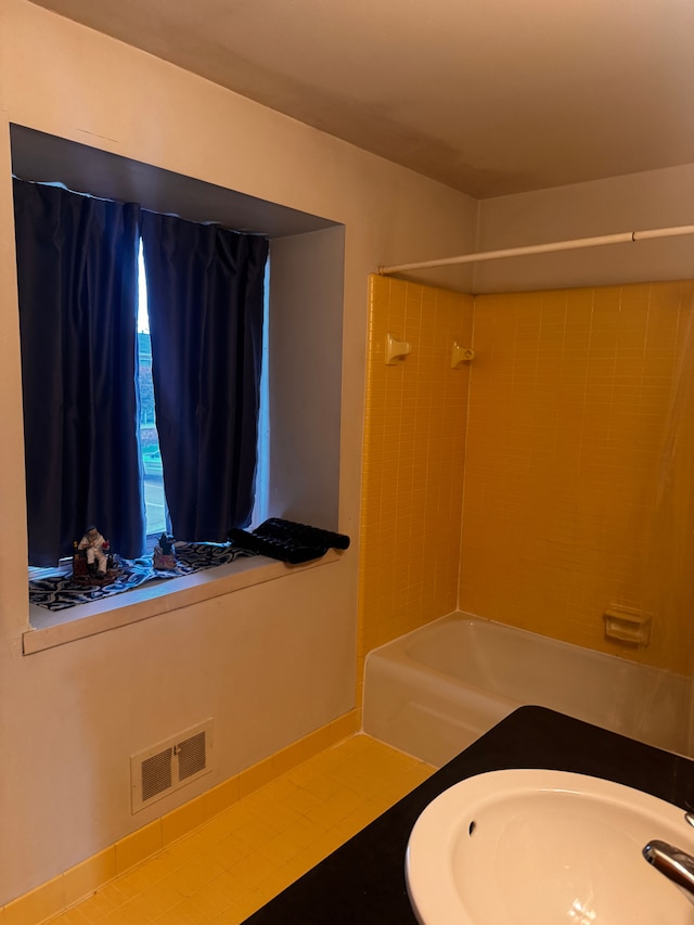bathroom with visible vents, a sink, and bathtub / shower combination