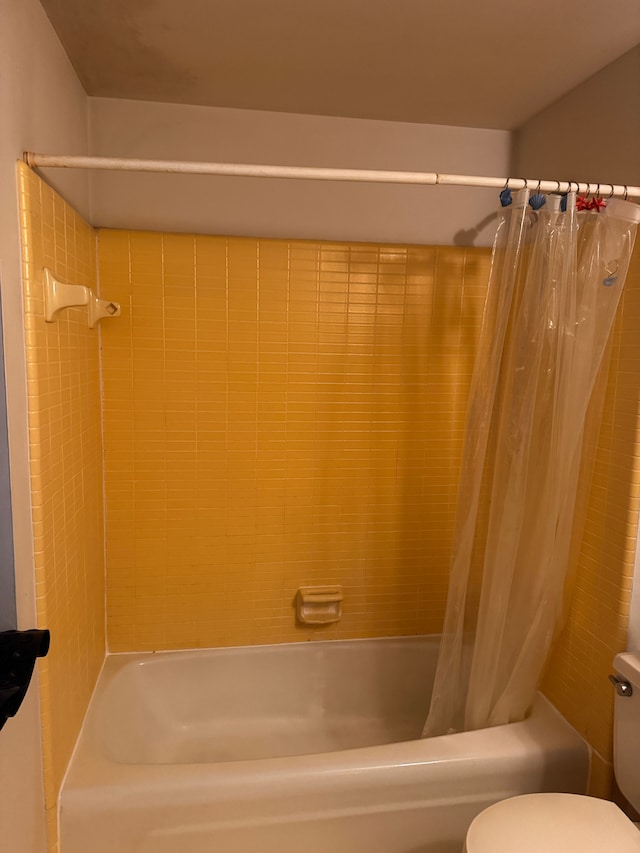 bathroom with toilet and shower / bath combination with curtain