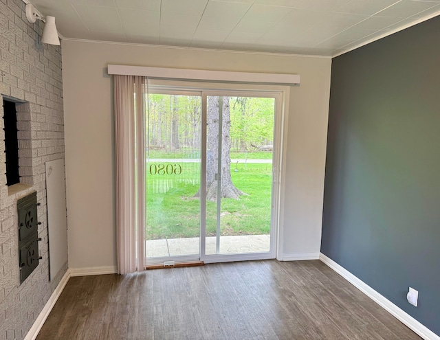 unfurnished living room featuring baseboards, ornamental molding, and wood finished floors