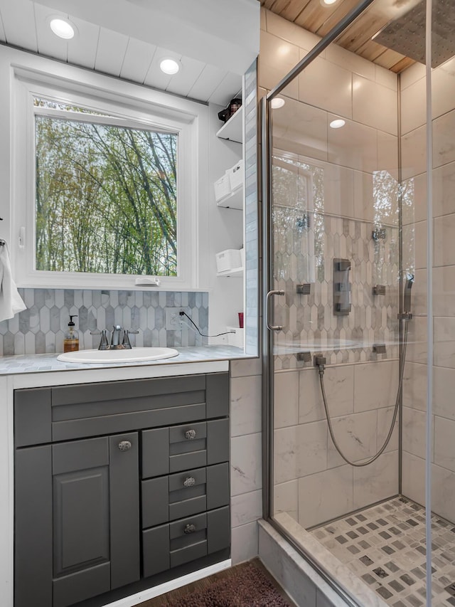 bathroom featuring vanity, tasteful backsplash, a shower stall, and recessed lighting