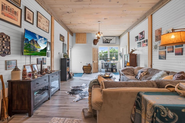 living room with a notable chandelier, wood walls, wood ceiling, and wood finished floors