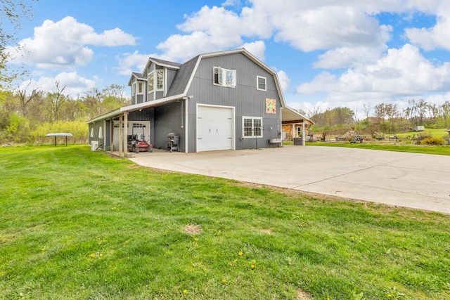 view of property exterior with a garage, a gambrel roof, a yard, and driveway