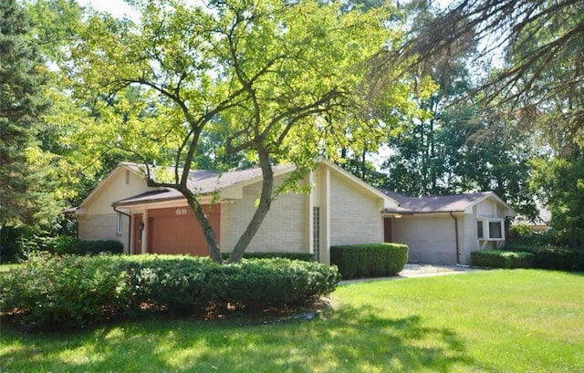 view of home's exterior with an attached garage, brick siding, and a lawn