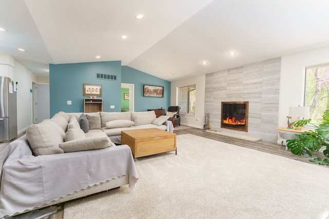 living area with healthy amount of natural light, lofted ceiling, a fireplace, recessed lighting, and baseboards