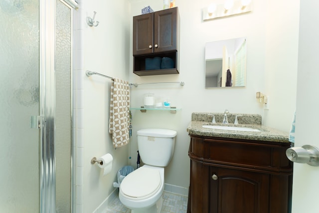 bathroom featuring toilet, a stall shower, baseboards, vanity, and tile patterned floors