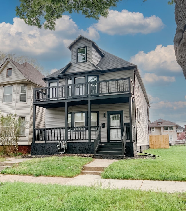2439 Sheridan St, Detroit, MI 48214 - view of front of home featuring fence, roof with shingles, a front lawn, a balcony, and covered porch