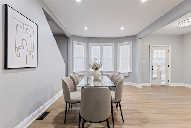 dining room featuring baseboards, visible vents, and light wood-style floors