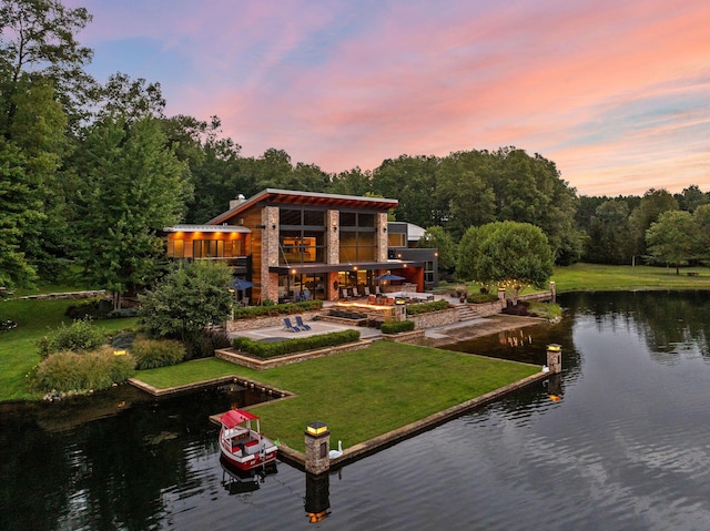 10463 W H Ave, Kalamazoo, MI 49009 - back of property at dusk featuring a lawn, a patio, and a water view