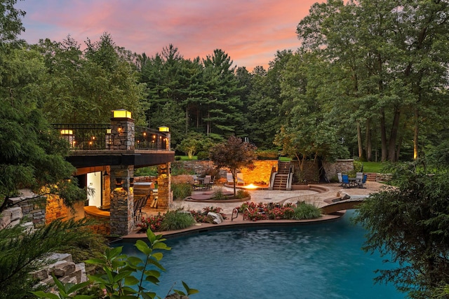 10463 W H Ave, Kalamazoo, MI 49009 - pool at dusk with a patio, an outdoor fire pit, an outdoor pool, and stairs