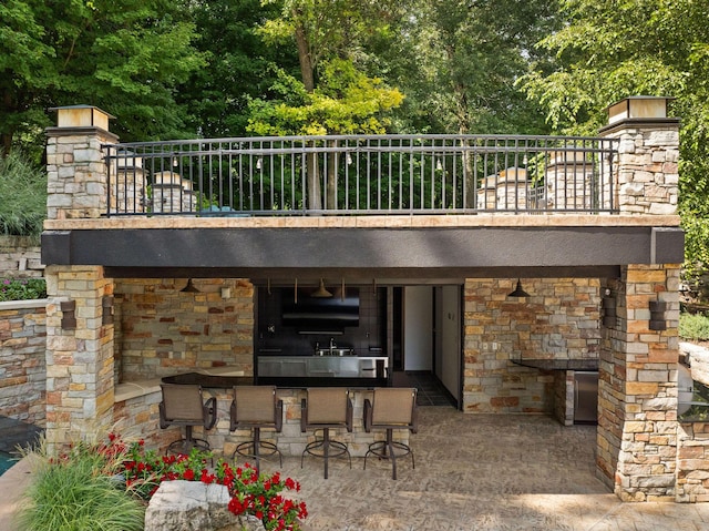 10463 W H Ave, Kalamazoo, MI 49009 - exterior space with stone siding, a patio area, and outdoor dry bar