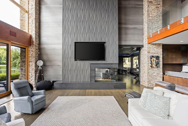 10463 W H Ave, Kalamazoo, MI 49009 - living room featuring a glass covered fireplace, a towering ceiling, wood finished floors, and a wealth of natural light
