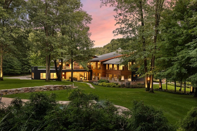 10463 W H Ave, Kalamazoo, MI 49009 - back of property at dusk featuring a yard and stone siding