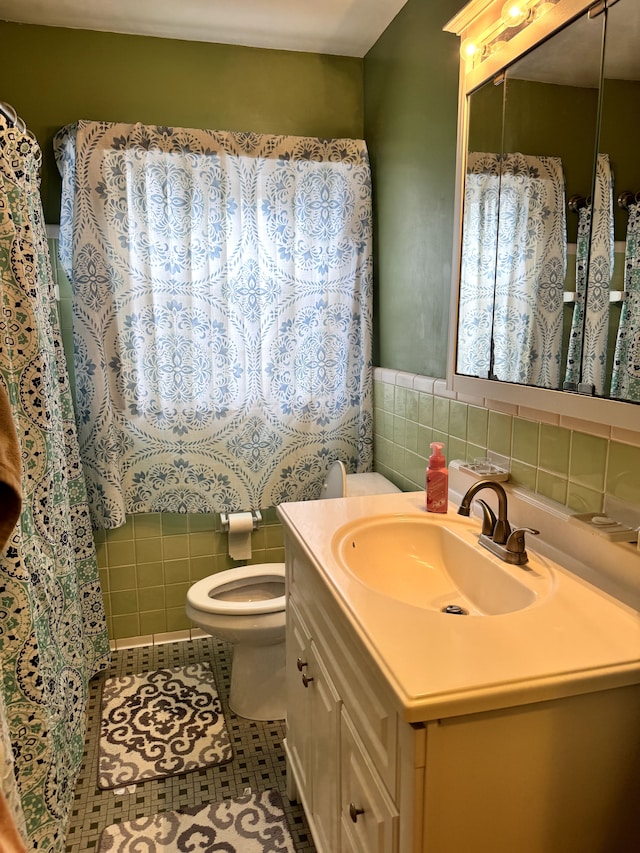 16545 E 8 Mile Rd, Eastpointe, MI 48021 - bathroom with tile walls, tile patterned floors, vanity, and toilet