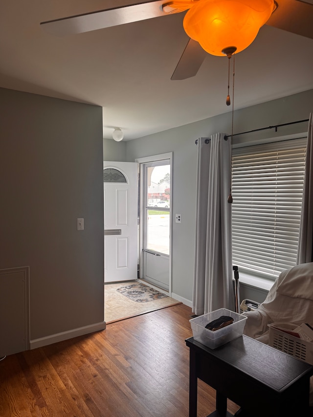 entrance foyer with baseboards, a ceiling fan, and wood finished floors