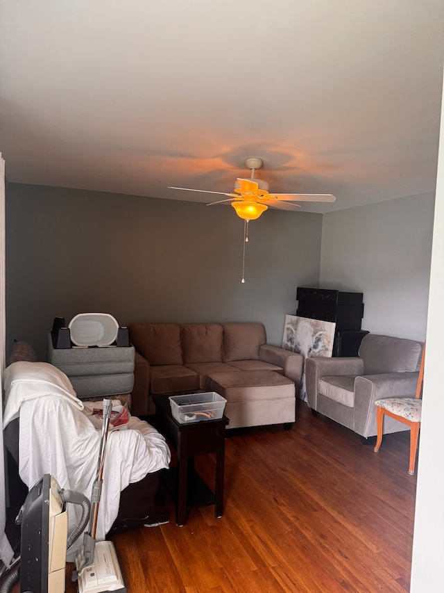 living area featuring ceiling fan and dark wood finished floors
