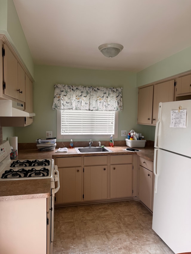 kitchen featuring white appliances, under cabinet range hood, a sink, and cream cabinets