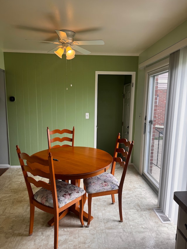 dining room featuring ceiling fan, ornamental molding, and visible vents