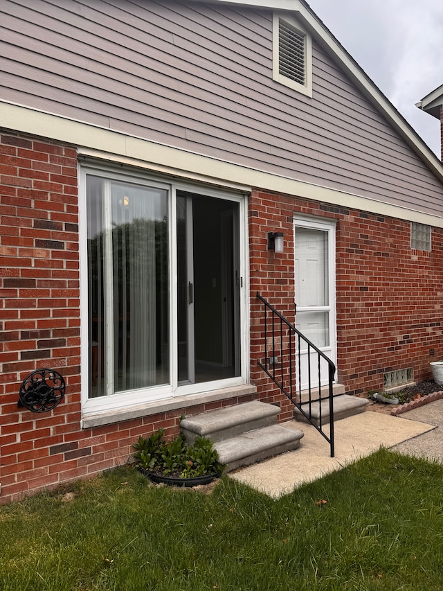 doorway to property with brick siding