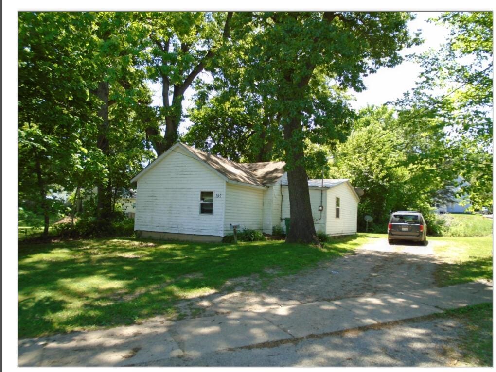 view of front of house with dirt driveway and a front yard
