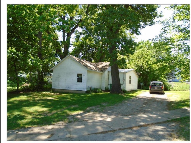 view of front of house with dirt driveway and a front yard