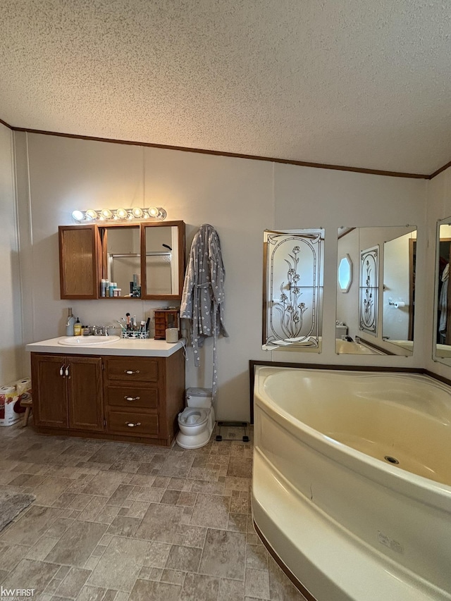 bathroom featuring crown molding, stone finish flooring, a textured ceiling, and vanity