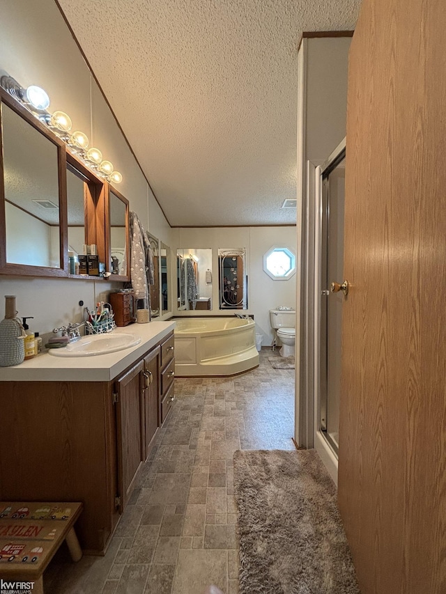 bathroom with vanity, a garden tub, toilet, a textured ceiling, and a shower stall