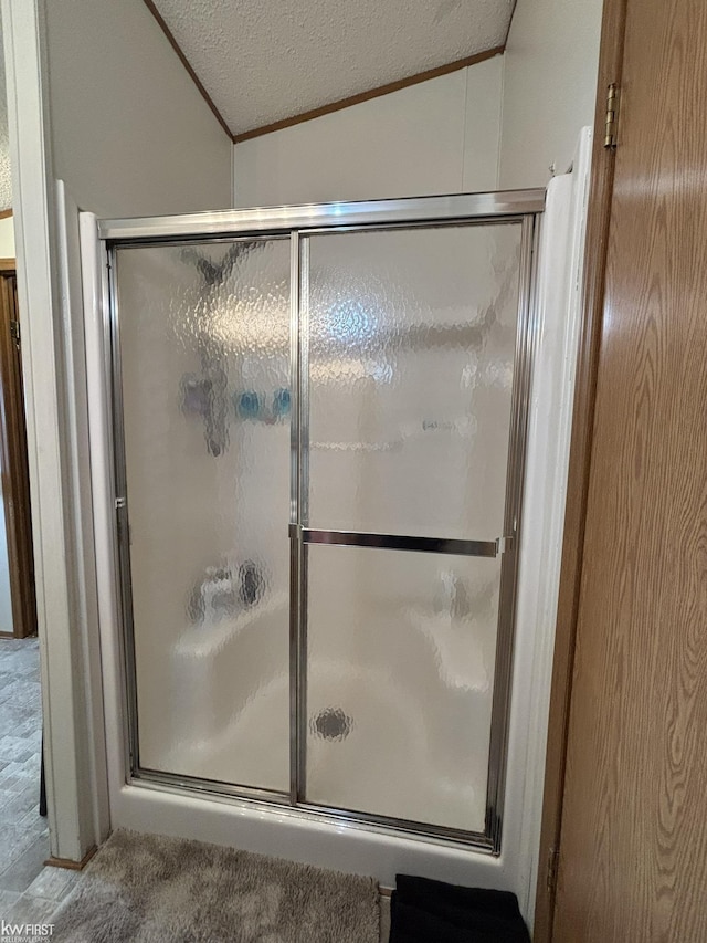 full bathroom with a textured ceiling, a shower stall, and ornamental molding