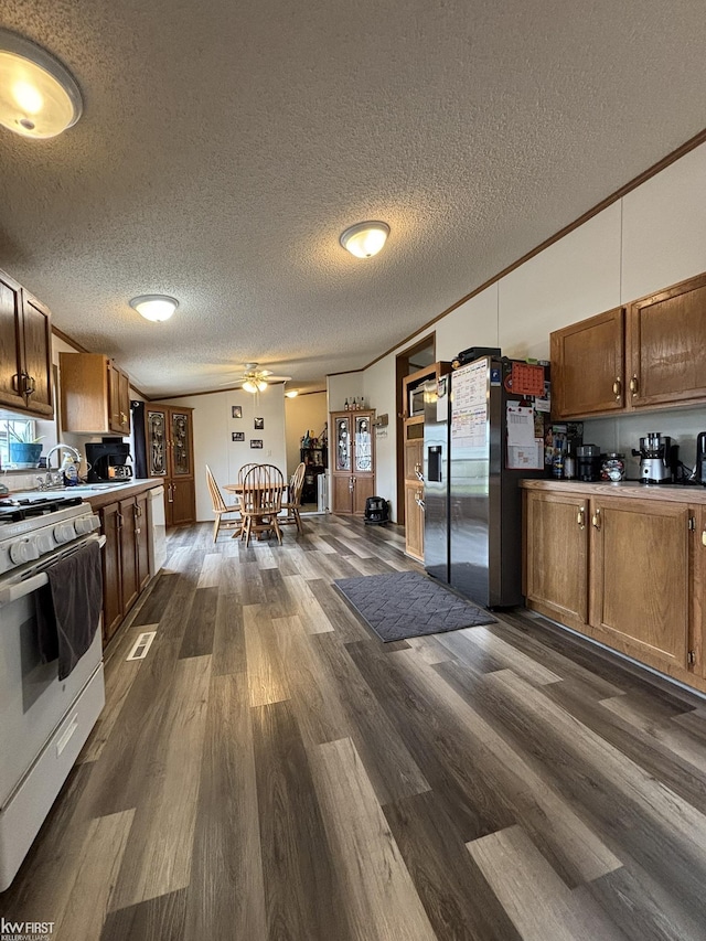 kitchen with stainless steel fridge with ice dispenser, gas range gas stove, dark wood-style floors, and a textured ceiling