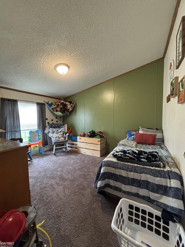 bedroom featuring crown molding, carpet flooring, a textured ceiling, and a decorative wall