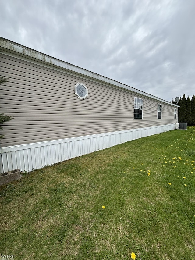 view of property exterior featuring central air condition unit and a yard