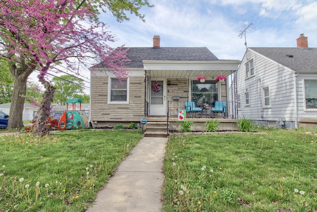 bungalow-style house with a porch, a front yard, and a chimney