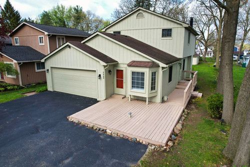 traditional-style house featuring an attached garage and aphalt driveway