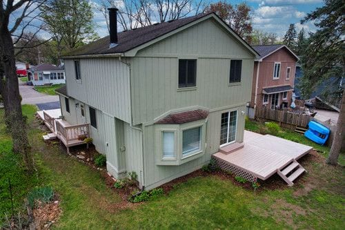 back of property featuring a chimney and a deck
