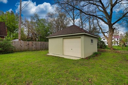 detached garage featuring fence
