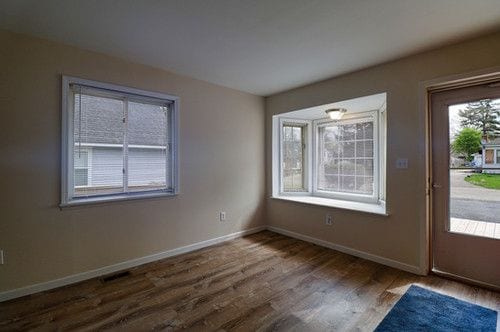 entryway featuring baseboards, wood finished floors, and visible vents