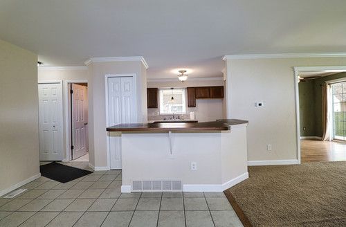 kitchen with visible vents, crown molding, dark countertops, baseboards, and a wealth of natural light